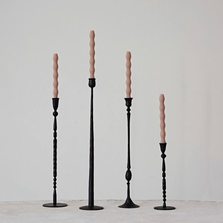 four candles are lined up in the shape of three poles with one candle sticking out of it