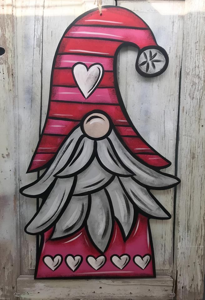 a red and white door with a santa clause on it's face, surrounded by hearts