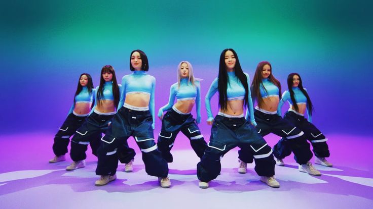 a group of young women in blue and black outfits dancing on purple and green background