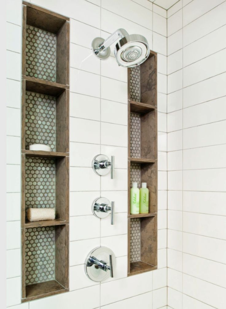 a shower with two shelves on the wall