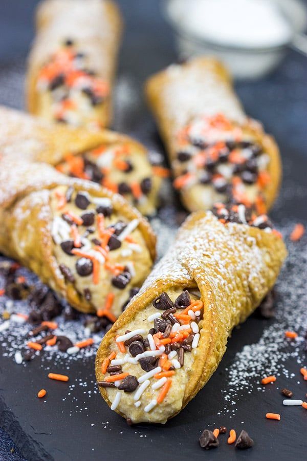 some food is laying out on a black plate with orange and white sprinkles