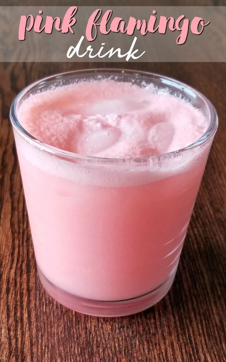 a pink drink sitting on top of a wooden table