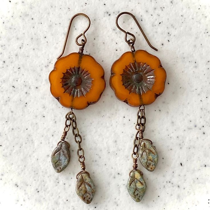 These earrings will definitely be eye catching. Perfect for any occasion, the orange Hibiscus Flower and green leaves will compliment many outfits. Crafted with a 22mm table cut hibiscus flower bead accented with  green leaf  beads on antique brass wire and chain. Delivered in a cute hand made origami box Orange Hibiscus Flower, Orange Hibiscus, Leaf Beads, Earrings Ideas, Lampwork Jewelry, Blue Dragonfly, Origami Box, Wrap Earrings, Dragonfly Necklace