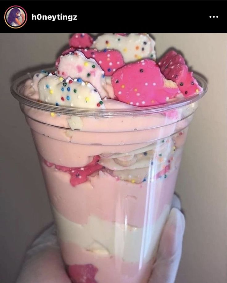 a cup filled with lots of pink and white sprinkles on top of it