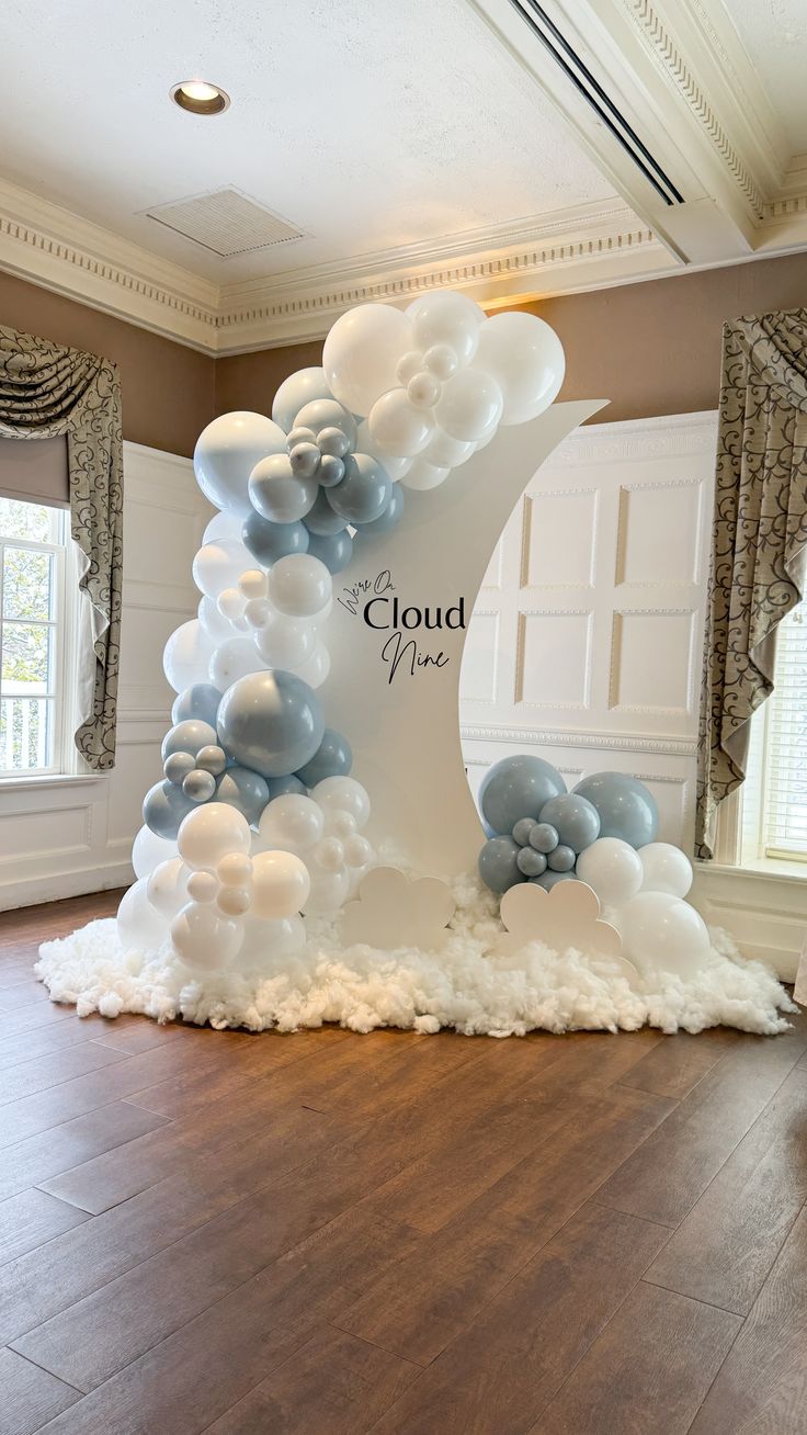 a large white and blue cloud sculpture on top of a hard wood floor