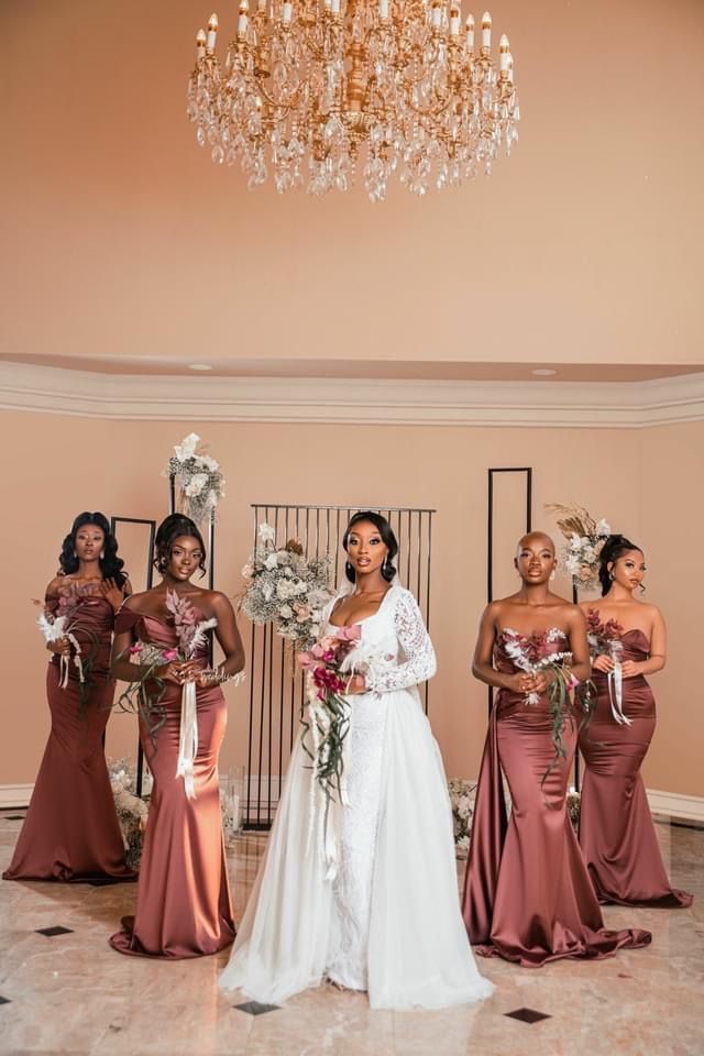 a group of women standing next to each other in front of a chandelier