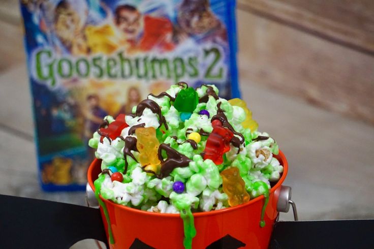 a bucket filled with gummy bears sitting on top of a table next to a book