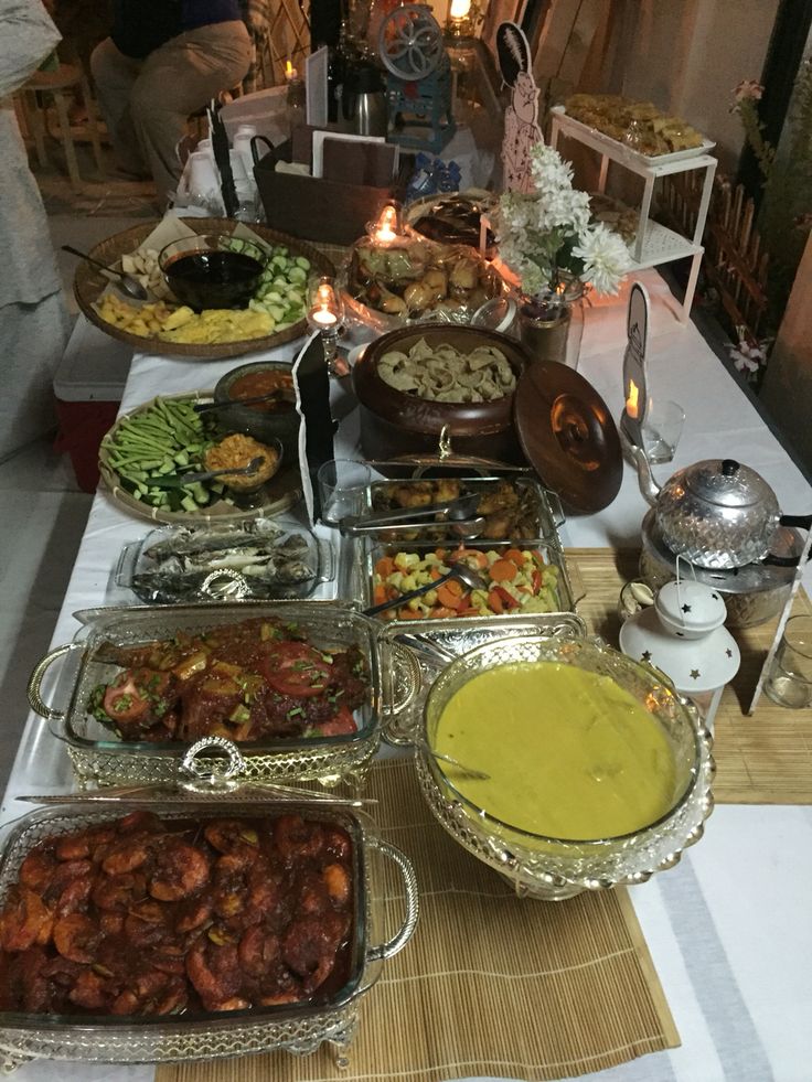 a table filled with lots of food on top of a white tablecloth covered table