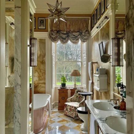 a bathroom with two sinks and a bathtub in the middle of it, surrounded by windows