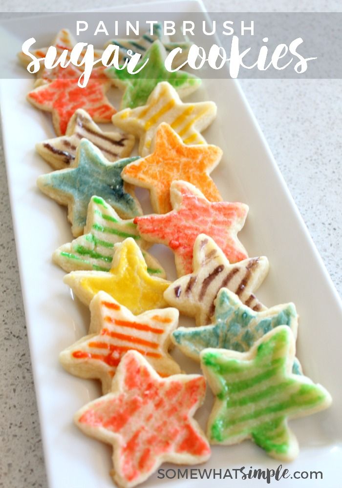 colorful sugar cookies on a white plate with the words paintbrush sugar cookies written above them