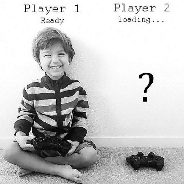 a young boy sitting on the floor next to a video game controller