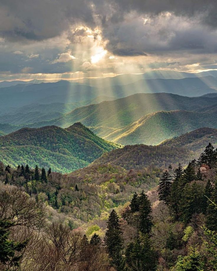 the sun shines through clouds over mountains in the blue ridge range, nca