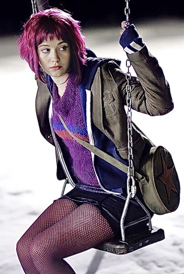 a woman with pink hair sitting on a swing