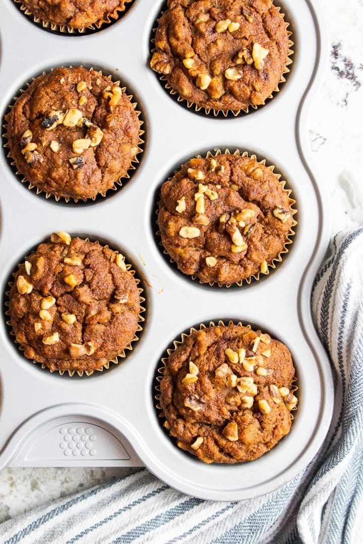 muffins in a cupcake pan with nuts on top