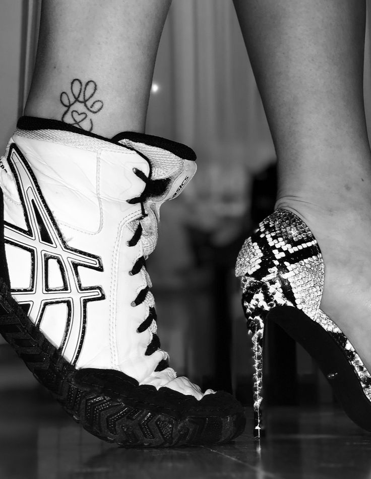 black and white photograph of woman's legs with high heeled shoes on the floor