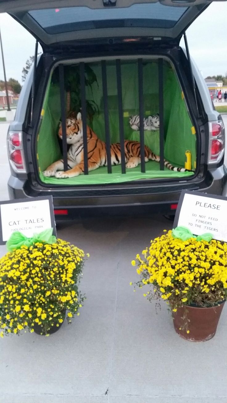 two stuffed tigers sitting in the back of a car with flowers and signs on it