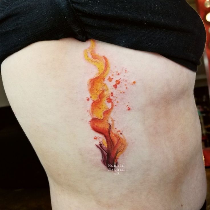 a woman's stomach with a fire tattoo on her belly and the bottom part of her lower back