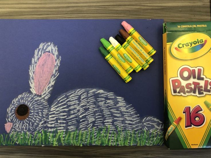 a drawing of a bunny with crayons on it and some other items next to it