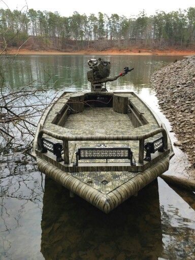 a small boat sitting on top of a body of water next to a shore line