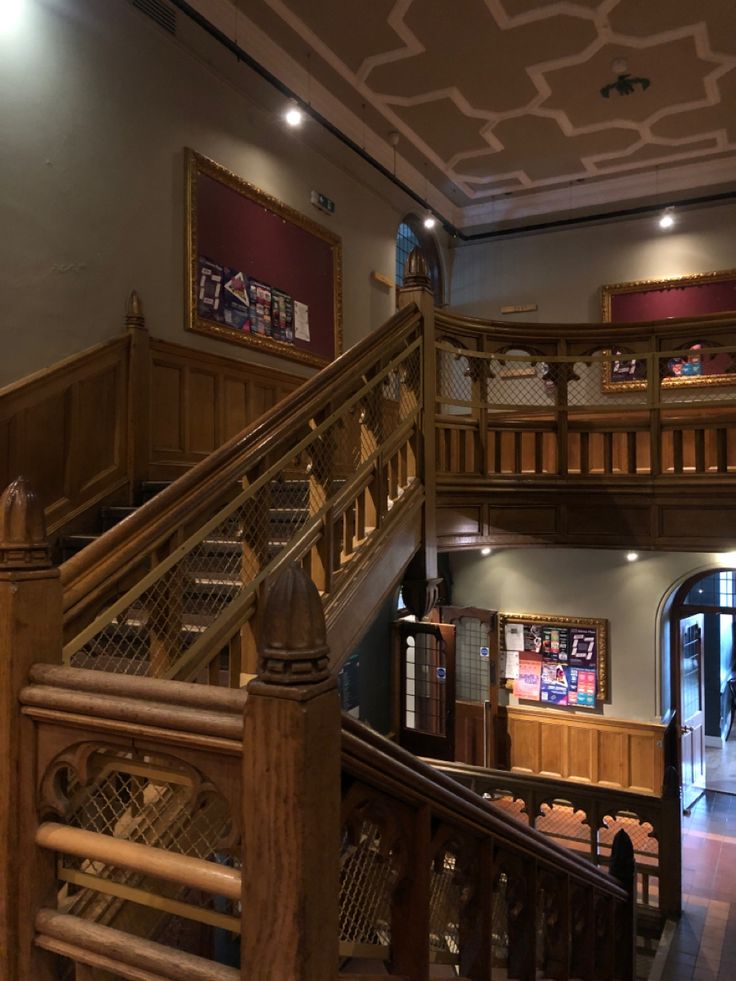 the inside of a building with stairs and pictures on the wall