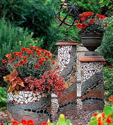 three planters with flowers in them sitting on the ground