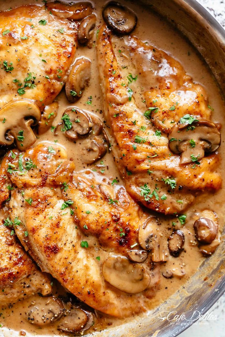 chicken with mushrooms and gravy in a skillet on a white tablecloth