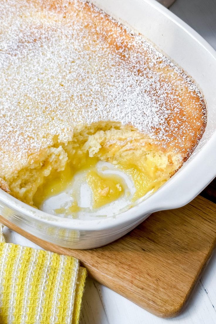 a casserole dish is covered with powdered sugar and sits on a cutting board