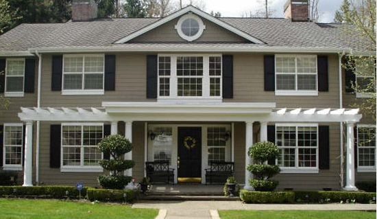 a large house with black shutters and white trim on the front door is shown