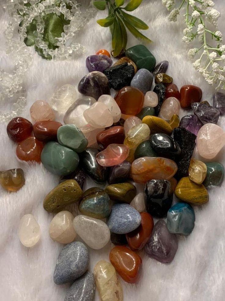 some rocks and flowers on a white blanket