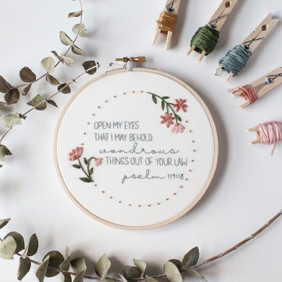 a cross - stitch pattern with words on it surrounded by thread and spools