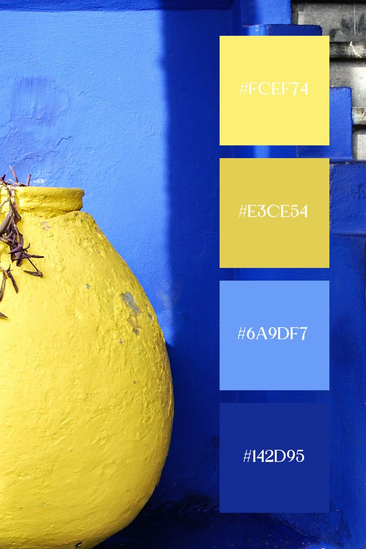 a large yellow vase sitting next to a blue wall