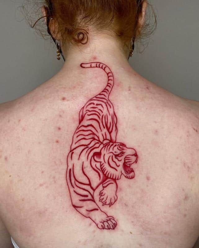 a woman with a tattoo on her back that has a tiger on it's chest