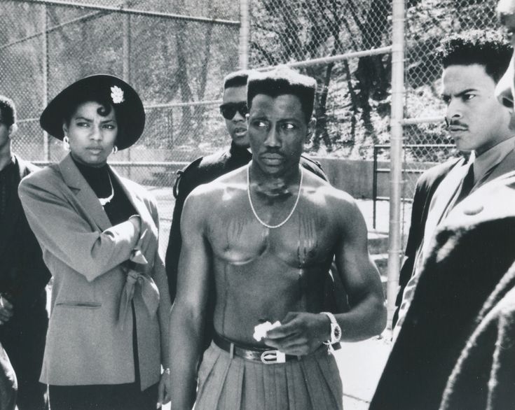 a group of young men standing next to each other in front of a fenced area