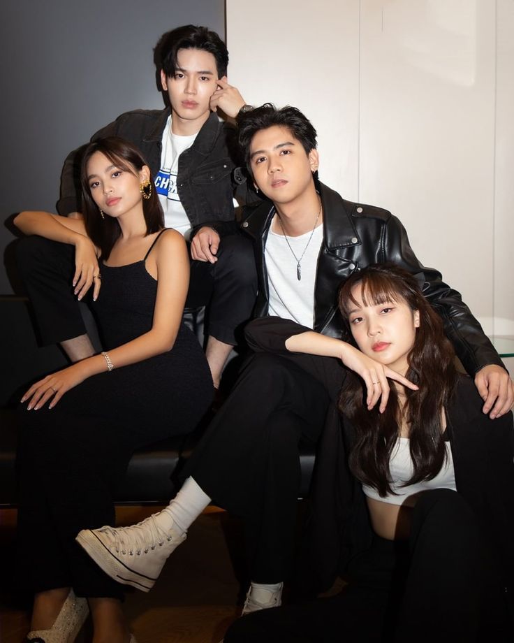 four people sitting on a couch posing for the camera