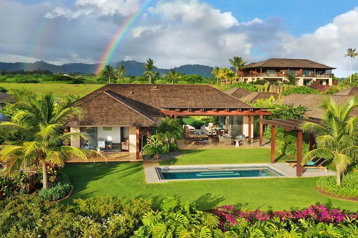 an aerial view of a house with a pool and palm trees in the foreground