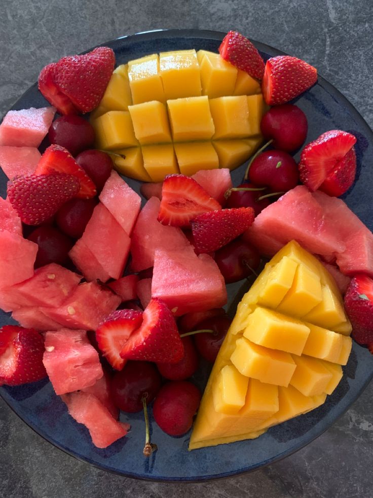 a blue plate topped with sliced fruit and watermelon