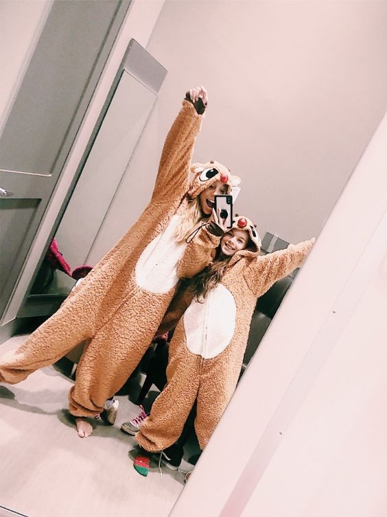 two people dressed in animal costumes taking a selfie with their hands up while standing next to each other