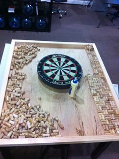 a wooden table topped with a dart and lots of wine corks on top of it