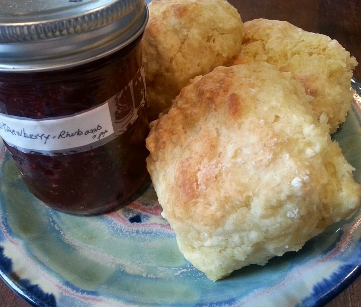 two biscuits on a plate with jam in a jar