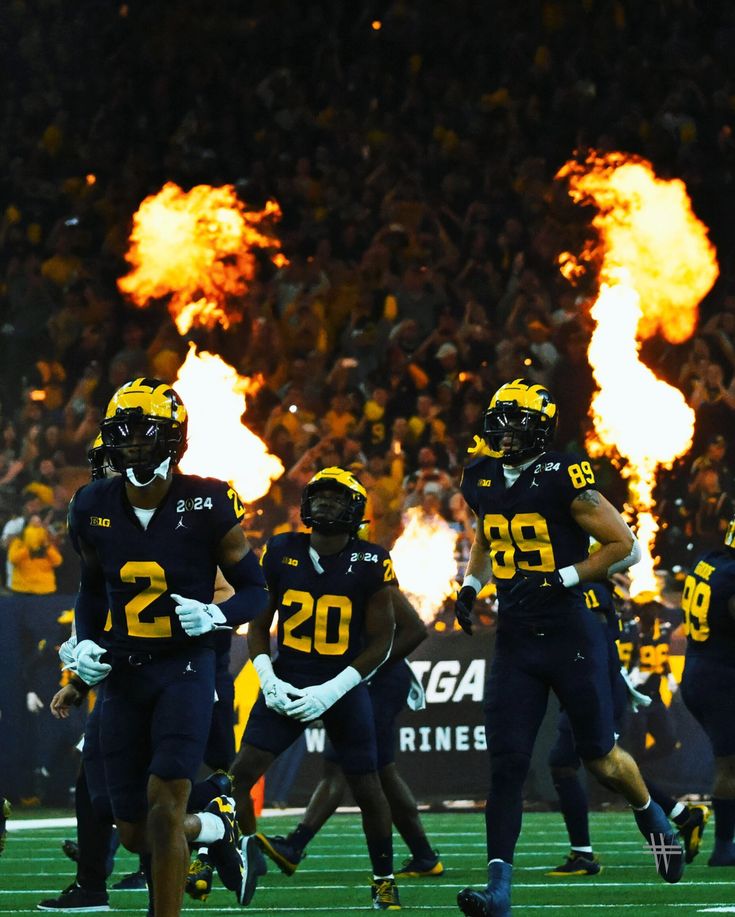 the football team is running onto the field with flames coming from their mouths and hands