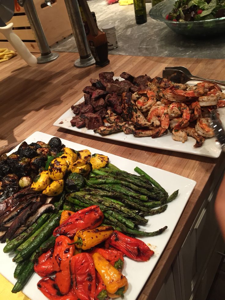 two white plates filled with different types of food on top of a wooden countertop