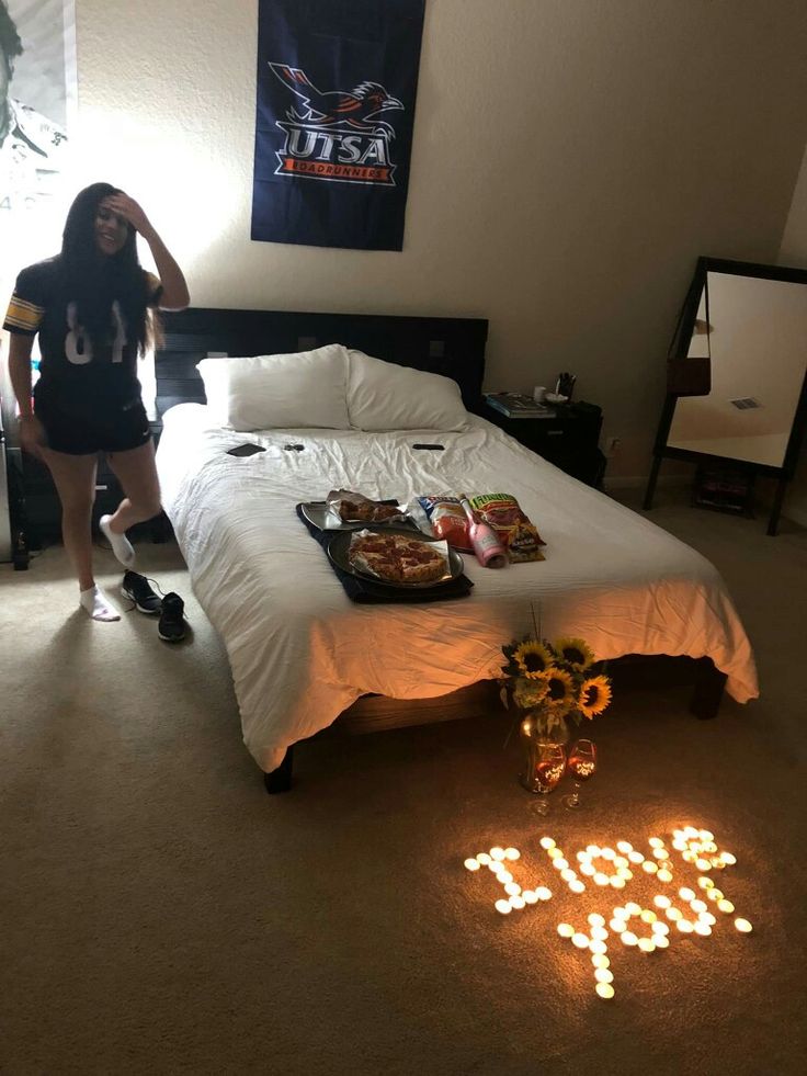 a woman standing in front of a bed next to a light that reads i love you