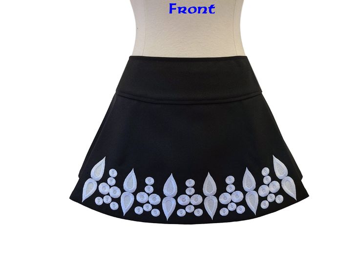 This fit-friendly Irish dance skirt is the perfect option for shows/competitions and will come in handy when your dancer is between dresses! The wrap-back style allows for an adjustable and comfortable fit. Crafted in the USA, this high-quality garment is made of black gabardine and features white embroidered crystal outlines and a Velcro closure around the back waist. Simply Prime skirts have two pleats in the front to allow for high kicks and quick movements. The skirts wrap around the back wi Fitted Black Pleated Swim Skirt, Fitted Flared Skort With Lined Skirt, Black Fitted Pleated Swim Skirt, Fitted Mini Swim Skirt With Lined Skirt, Fitted Mini Swim Skirt With Lining, Fitted Skirted Swim Skirt, Fitted Pleated Mini Swim Skirt, Fitted White Skort For Cheerleading, Fitted Skirt For Spring Dancewear