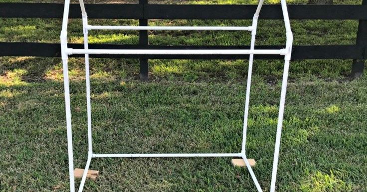 an ironing board sitting in the grass next to a fence