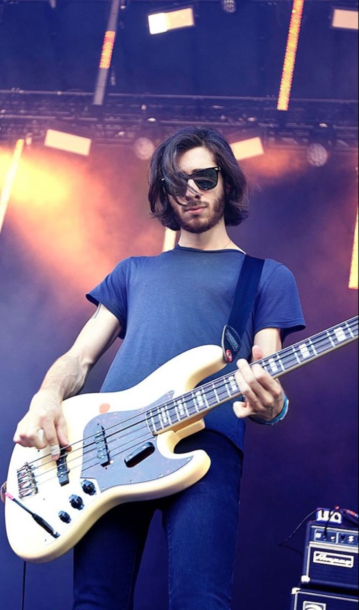 a man holding a guitar on top of a stage