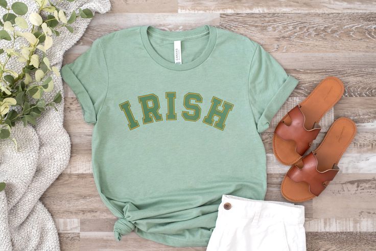 A simple & modern St Patricks Day graphic tee for women or men, perfect for celebrating the Irish holiday or giving as a St Patricks gift for a wife, sister or friend. Features a minimalistic green and yellow gold arched "IRISH" text design printed on our cozy heather sage green gender neutral crew neck tee. Made from quality, buttery-soft airlume cotton that provides all day comfort, breathability & durability. ☑ 52% airlume cotton + 48% polyester☑ Buttery-soft, light-weight & breathable materi Irish Tshirts, Lucky Shirt, Graphic Tops, Tees For Women, Text Design, Crew Neck Tee, Soft Light, Celebration Of Life, St Patricks