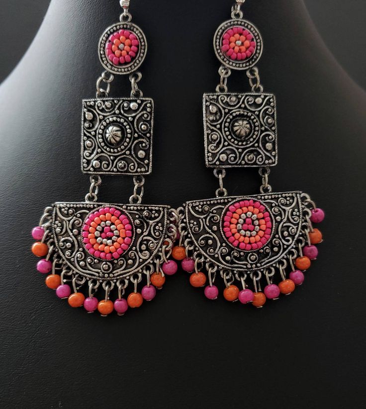 Gather compliments wearing this hand crafted pink, blue or multicolor beaded India chandbali earrings and necklace in oxidized blackened silver, so as to create the patina of a vintage tribal piece. The blackening makes all the fine details stand out dramatically! 5 strand chain drapes effortlessly and dramatically from the bottom of the necklace. Adjustable length using sliding bead on black cotton cord, for a comfortable fit, drop from 9 1/2 in to 18 in. Earrings measure 3 2/2 x 1 3/4 in. on f Metal Fusion Style Chandbalis For Festivals, Handmade Chandbalis For Festival, Fusion Style Dangle Chandbalis For Festivals, Fusion Style Chandbalis Dangle For Festivals, Fusion Style Metal Chandbalis With Latkans, Fusion Style Oxidized Chandbalis For Gifts, Fusion Style Oxidized Chandbalis As Gift, Fusion Style Oxidized Chandbalis Gift, Handmade Temple Jewelry Danglers For Festival