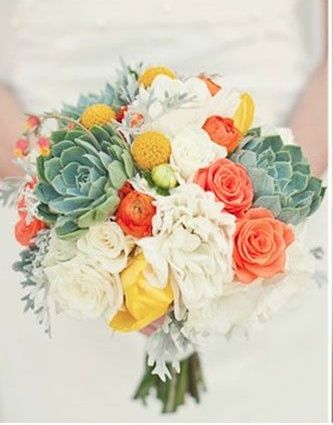 a bride holding a bouquet of flowers and succulents