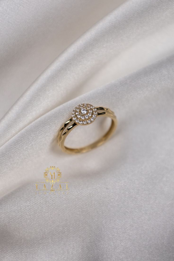 a diamond ring sitting on top of a white cloth