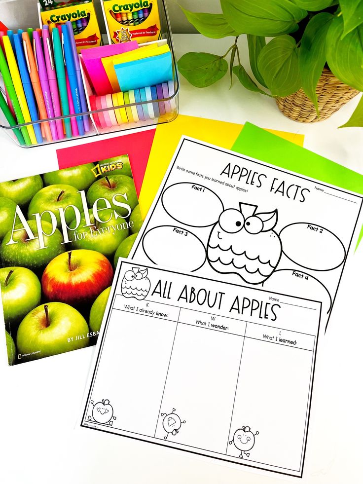 an apple themed book and coloring pages are on the table next to some pens, markers, and pencils